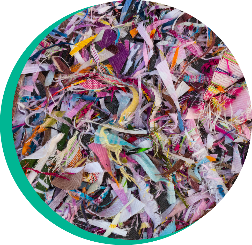 A pile of shredded fabric demonstrates that using a fiber-to-fiber process to recycle clothing requires shredding textiles so they can be separated into individual fibers.