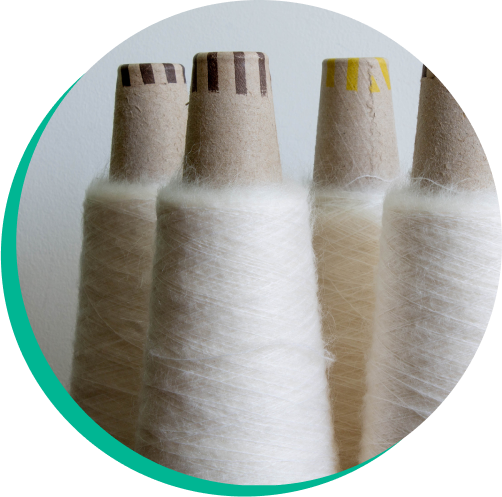 Spools of circular fiber ready to be used in textile manufacturing.