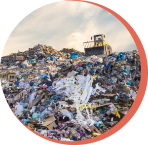 A large mountain of textile waste being moved by a bulldozer showing the harm that textile can make on the environment.